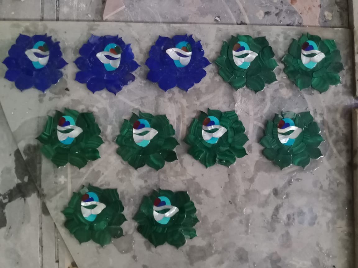 Prepared floral stone and shell motifs arranged on a tray before inlay placement