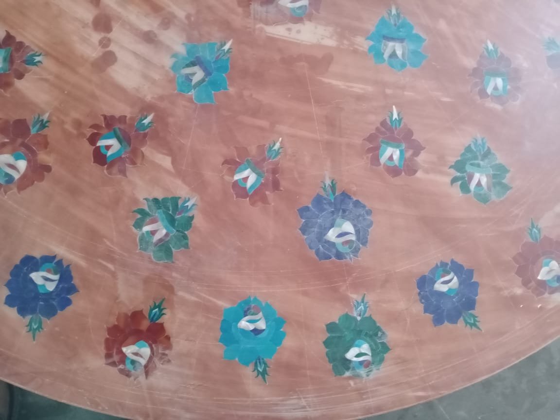 Floral inlay motifs arranged across a round tabletop during production